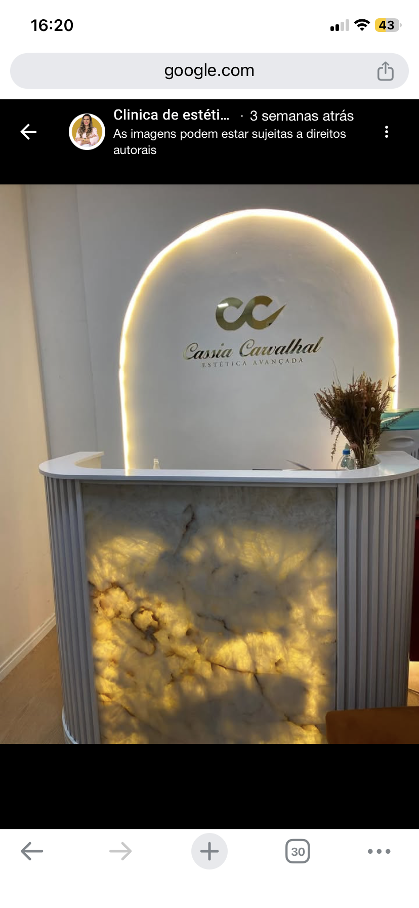 Recepção da Clínica Cássia Carvalhal — Ambiente premium com logo iluminado